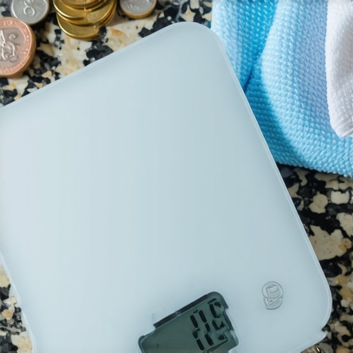 Professional Kitchen Scale Maintenance A kitchen scale being calibrated with nickels and cleaned with a cloth
